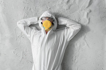 A man in white protective uniform, respirator and plastic transparent glasses.