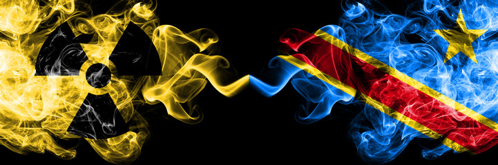 Democratic Republic of the Congo vs nuclear smoky mystic flags placed side by side. Thick colored silky smokes combination of Democratic Republic of the Congo flag and radioactive sign.