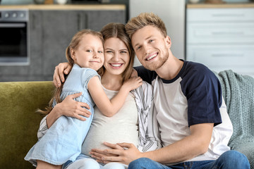 Obraz premium Beautiful pregnant woman with her family at home