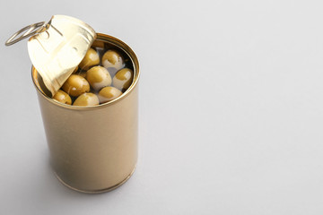 Tin can with olives on grey background