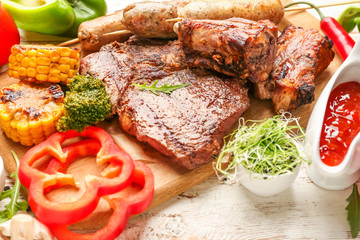 Tasty grilled meat with vegetables and sauce on table