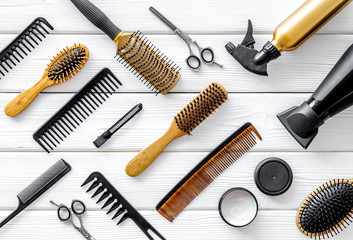 Set of professional hairdresser tools with combs, styling and sciccors on white wooden background...