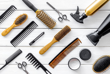 Set of professional hairdresser tools with combs, styling and sciccors on white wooden background top view pattern