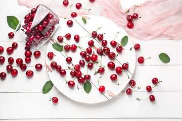 Scattered ripe cherry on white wooden background