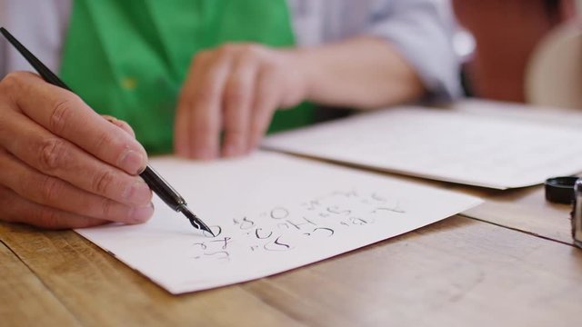Retired man in an arts class learning calligraphy handwriting