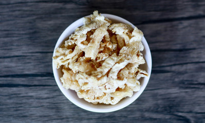 Chicken feet crackers or kripik ceker on wood background. 