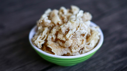 Chicken feet crackers or kripik ceker on wood background. 