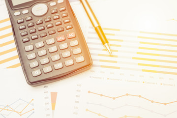 Data analysis with calculator from charts on desk at office. business concept.