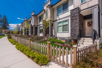 Beautiful exterior of newly built luxury home. Yard with green grass and landscape.