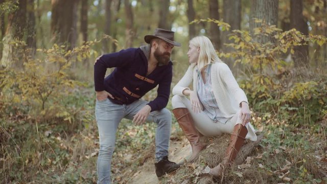 Young couple posing in Trendy Autumn Dress. High Fashion models man and woman posing in autumn park. Fashion portrait in autumn dress on nature background.