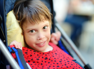 Portrait of a cute little disabled girl in a wheelchair. Child cerebral palsy. Inclusion.