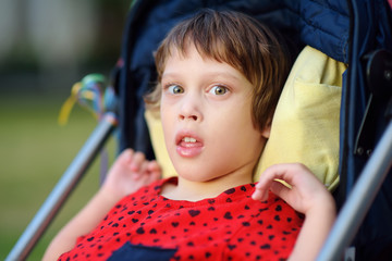 Portrait of a cute little disabled girl in a wheelchair. Child cerebral palsy. Inclusion.