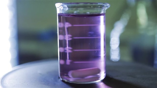 Lab Experiment with Centrifuge Machine. Chemistry Experiment with Purple Water on a Flask in the Lab.  Close-Up.  