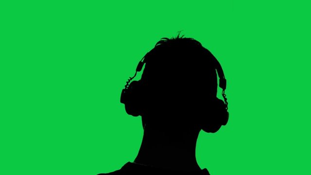 Man with headphones watching tv on green screen