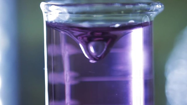 Lab Experiment with Centrifuge Machine. Chemistry Experiment with Purple Water on a Flask in the Lab.  Close-Up.  