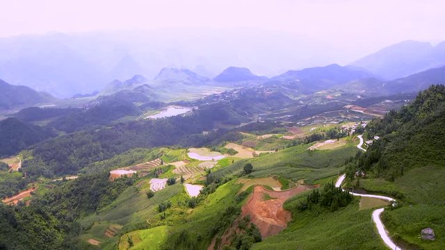 Drone camera pans over Karst Plateau jn Ha Giang province. Ma Pi Leng Pass aerial footage. View of road running through hilly countryside of Northern Vietnam.