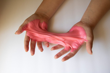 Hands Manipulating Pink Slime Hands pulling, twisting, squeezing slime. Slime resembles bubble gum. Gooey, stretchy, flexible, satisfying, tactile experience. Gross texture. Childhood fun. Innocent pl
