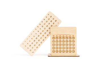 Wooden perpetual calendar made of light wood with pencil stand isolated on white background.