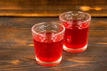 red homemade strawberry or raspberry wine or liquor on wooden table