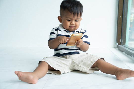 cute little asian baby boy play smart phone