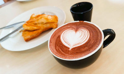 Fresh curry pie on white plain dish and hot chocolate. Brakefast in bakery shop.