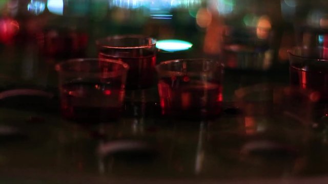 Shoots laid out on a table at a bar. Cocktail shots in small glasses. Drinking game, drinking friends.