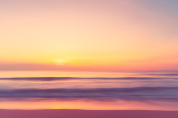 Obraz na płótnie Canvas Motion blur tropical sunset beach with bokeh sun light wave abstract background.