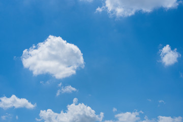 White clouds on a bright day with a blue sky in the background