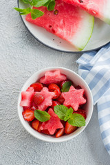 Summer salad with watermelon and strawberry on concrete background table