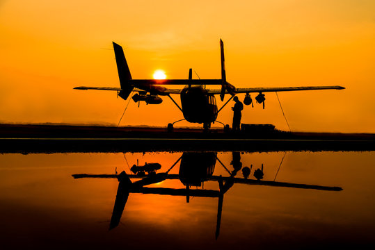 The silhouette helicopter parking landing on offshore platform and refection picture on ground floor at sun set sky background.