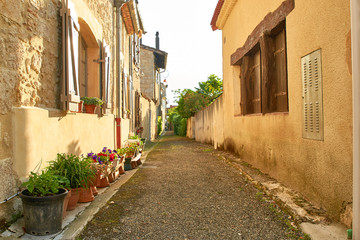Fototapeta na wymiar Ruelle de village, murs de pierre et jardinières