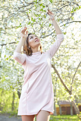 girl with flowers. gorgeous model in the spring garden. the girl near the tree in the spring. the concept of spring.