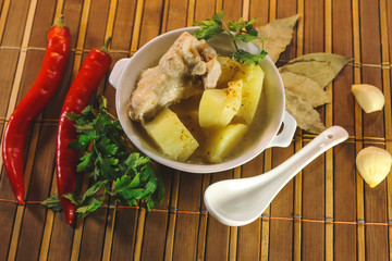 ready chicken and potatoes in a porcelain bowl. spicy seasonings to meat.