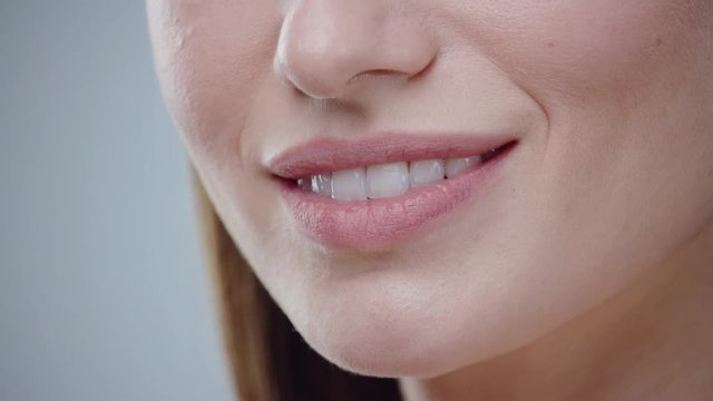 Close up young woman mouth smiling happy beautiful soft lips showing healthy teeth dental lead by hand on the face attractive female happy health cosmetics young slow motion