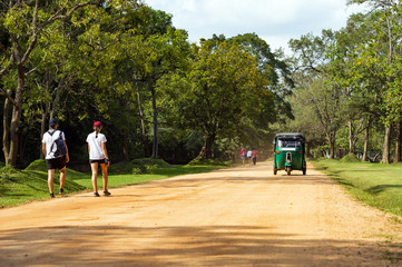 A couple of tourists is walking on a path that leads to the Lion Rock in Sigiriya. Lion Rock in Sigiriya is one of the most popular landmarks in Sri Lanka.