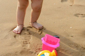 boy playing with beach toys on the beach in summertime - childhood and summer concept