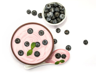 close up pink creamy homemade blueberries fruit yogurt with fresh green mint leaf on white background , top view or overhead shot