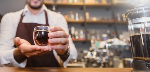 Closeup startup small business owner man hand holding espresso cup in coffee shop. Portrait of...