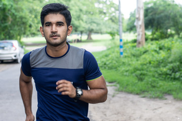 Athletic young man running in the sports ground. Healthy lifestyle , fitness and sports concept.