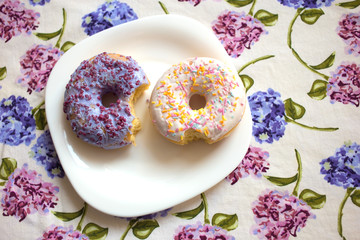 Two donuts with icing on a plate