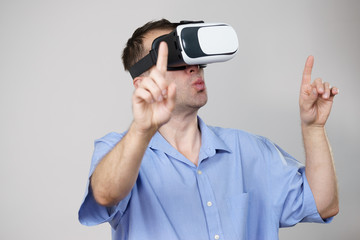 Man wearing virtual reality goggles on grey