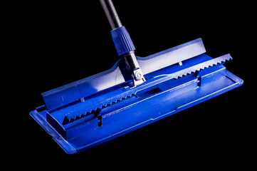 Blue plastic mop with clip for special cloth on a black background, isolate