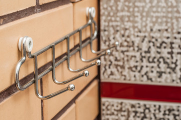 Chrome towel rack on a brick wall in the bathroom