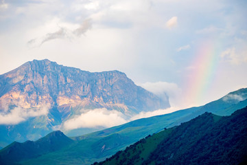 Scenic view of foggy mountains. Sunlit rocks and clouds