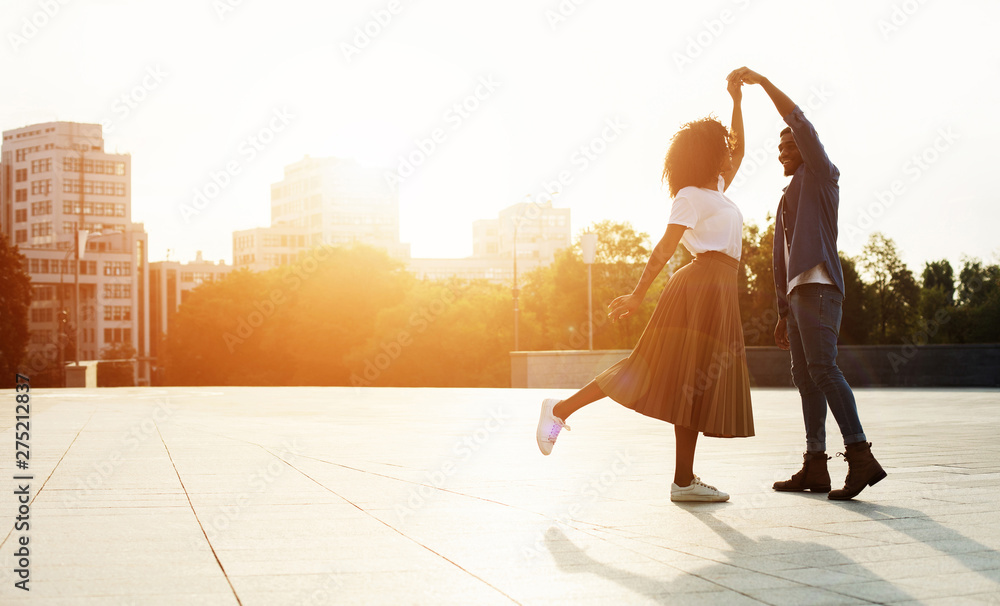 Wall mural Love is in the air. Romantic couple dancing at sunset