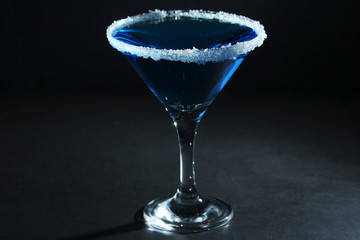 A glass with blue martini cocktail	