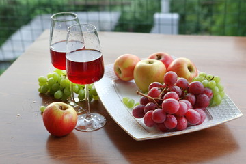 glass of red wine and grapes on wooden table