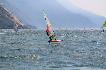 Windsurfer with foilboard causing the board to leave the surface of the water (Lake Garda, Italy)