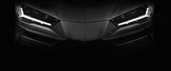 Silhouette of black sports car with LED headlights on black background