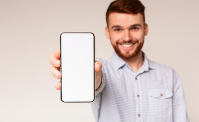 Young guy showing his phone with blank space on camera
